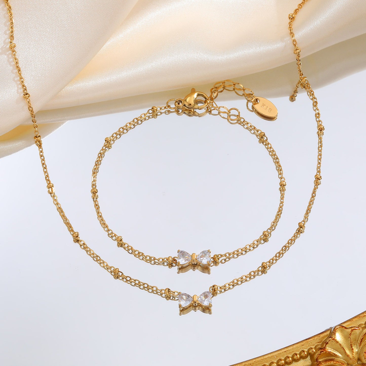 Delicado collar de lazo de acero inoxidable Kemstone con circonitas de cristal y cadena de cuentas. Joyería minimalista en tono dorado para mujer. NC-1718