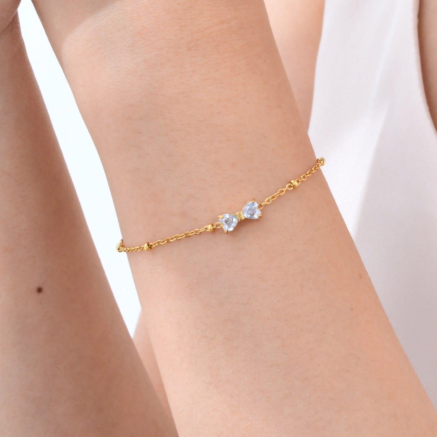 Delicado collar de lazo de acero inoxidable Kemstone con circonitas de cristal y cadena de cuentas. Joyería minimalista en tono dorado para mujer. NC-1718