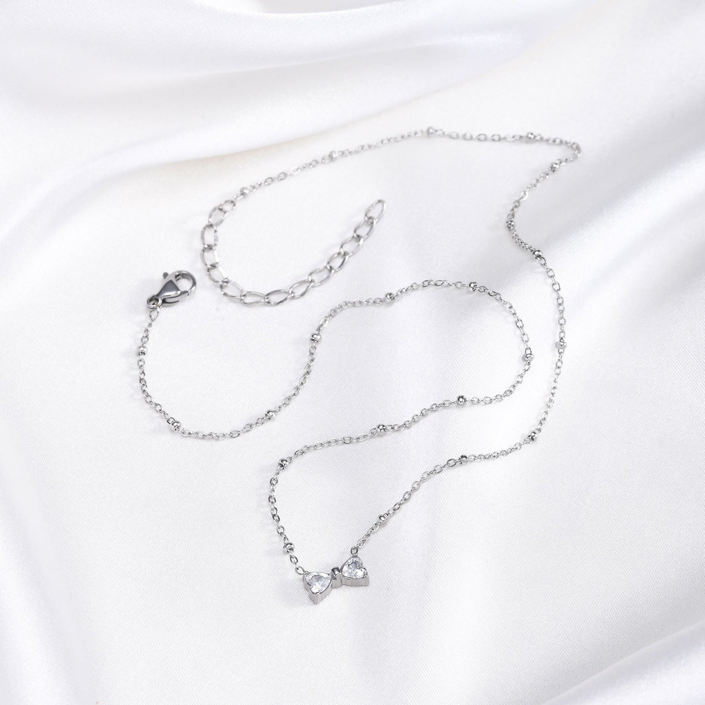 Delicado collar de lazo de acero inoxidable Kemstone con circonitas de cristal y cadena de cuentas. Joyería minimalista en tono dorado para mujer. NC-1718