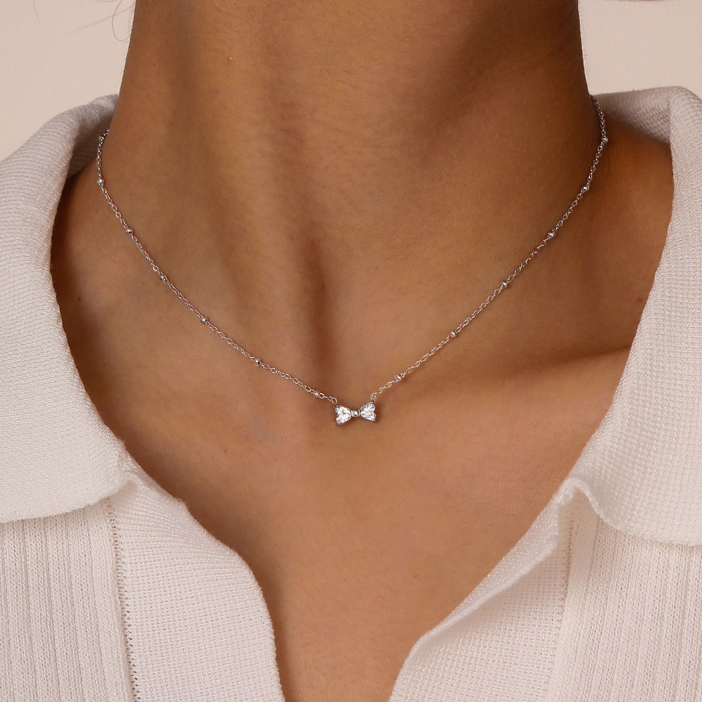 Delicado collar de lazo de acero inoxidable Kemstone con circonitas de cristal y cadena de cuentas. Joyería minimalista en tono dorado para mujer. NC-1718