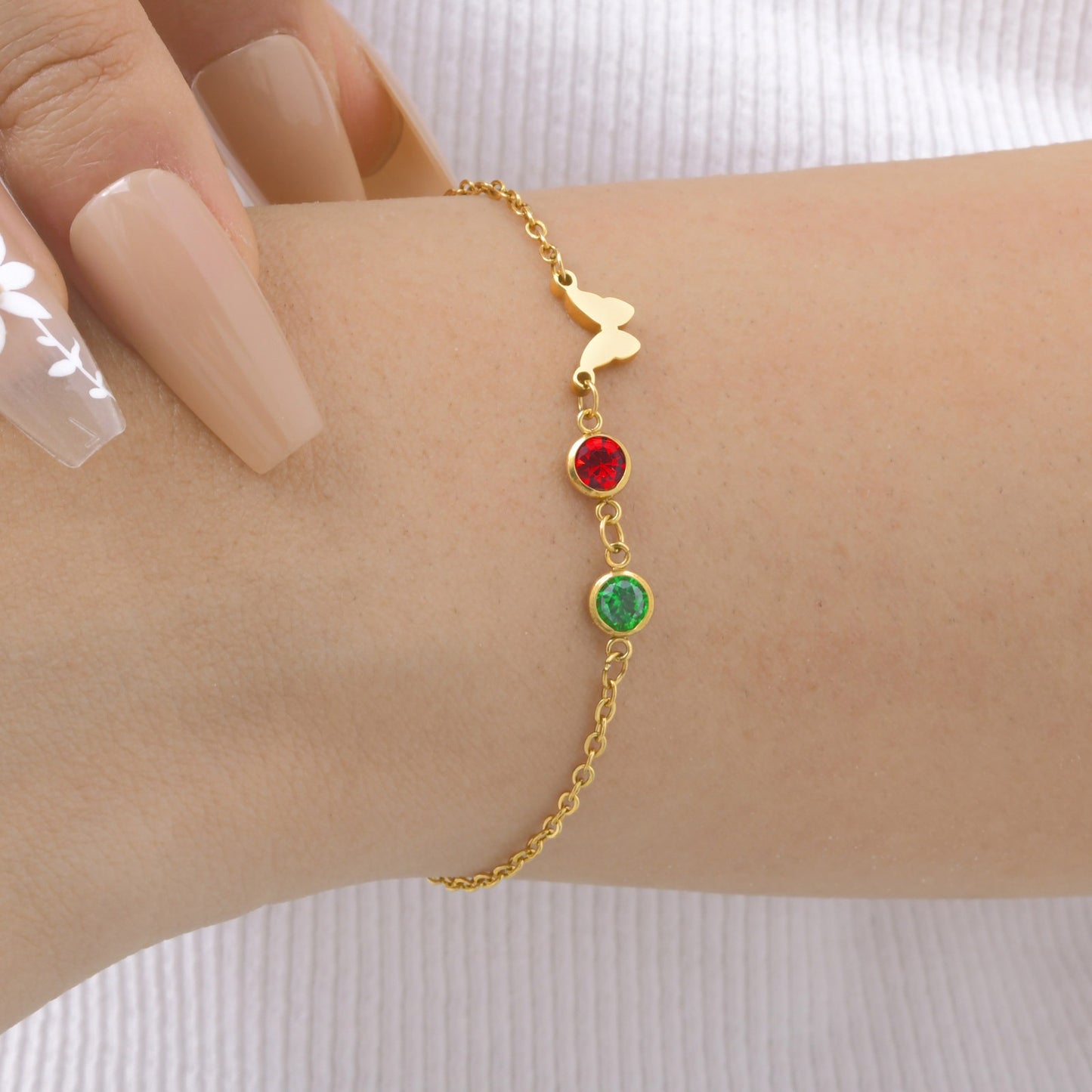 Pulsera de cadena cruzada plana de acero inoxidable Kemstone con detalles de mariposa y circonitas rojas y verdes. Elegante joyería para mujer, ideal para uso diario y regalo. BR-2142