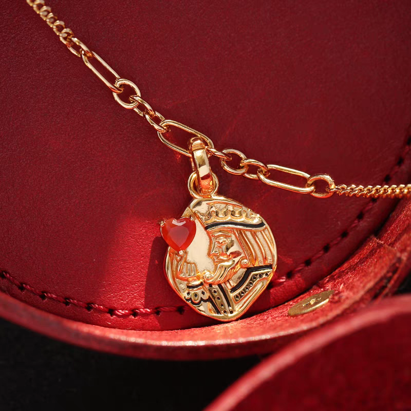 Collar con moneda vintage "El Corazón del Rey", diseño original artesanal de Kemstone. Colgante de corazón de póker con ágata roja y baño de oro en plata 925.
