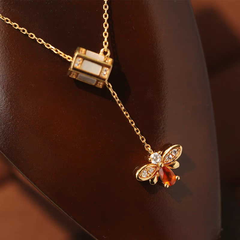 Collar de abeja "Buscador de Miel" de diseño original artesanal de Kemstone. Plata de ley 925, granate espesartita, concha blanca, circonita cúbica y cadena ajustable. Un regalo único de inspiración vintage.