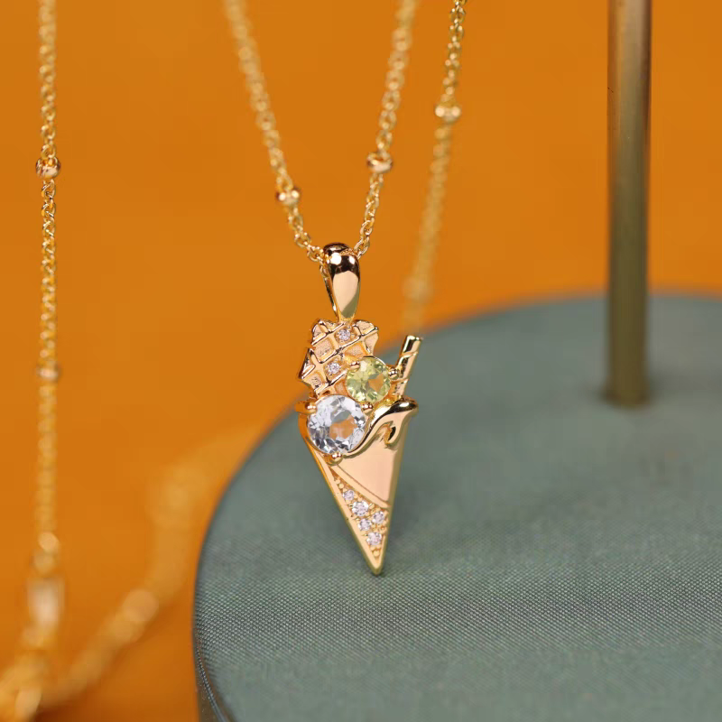 Collar de helado de la colección Sobremesa, diseño original artesanal de Kemstone. Colgante de plata 925 bañada en oro con topacio azul y peridoto. Un regalo de lujo para mujer.
