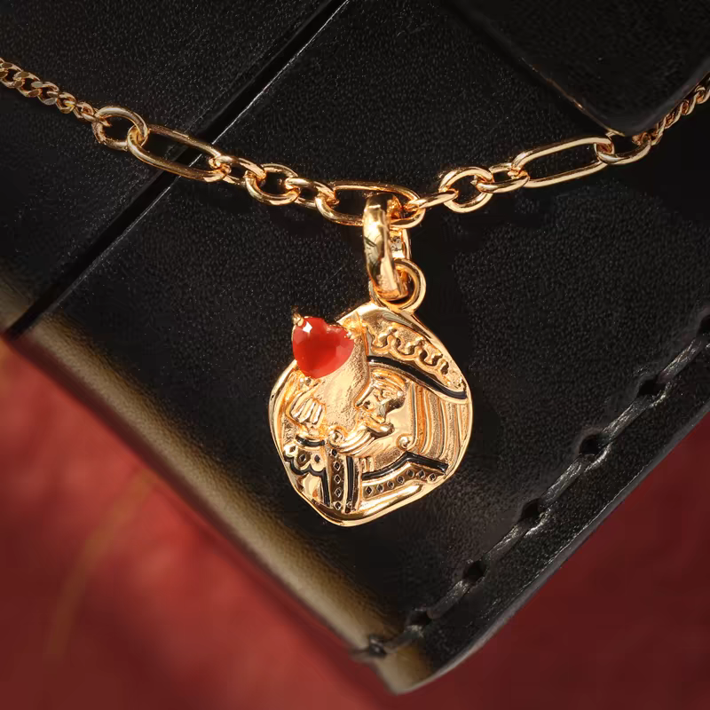 Collar con moneda vintage "El Corazón del Rey", diseño original artesanal de Kemstone. Colgante de corazón de póker con ágata roja y baño de oro en plata 925.