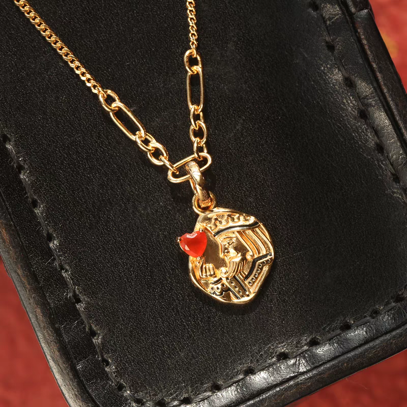 Collar con moneda vintage "El Corazón del Rey", diseño original artesanal de Kemstone. Colgante de corazón de póker con ágata roja y baño de oro en plata 925.