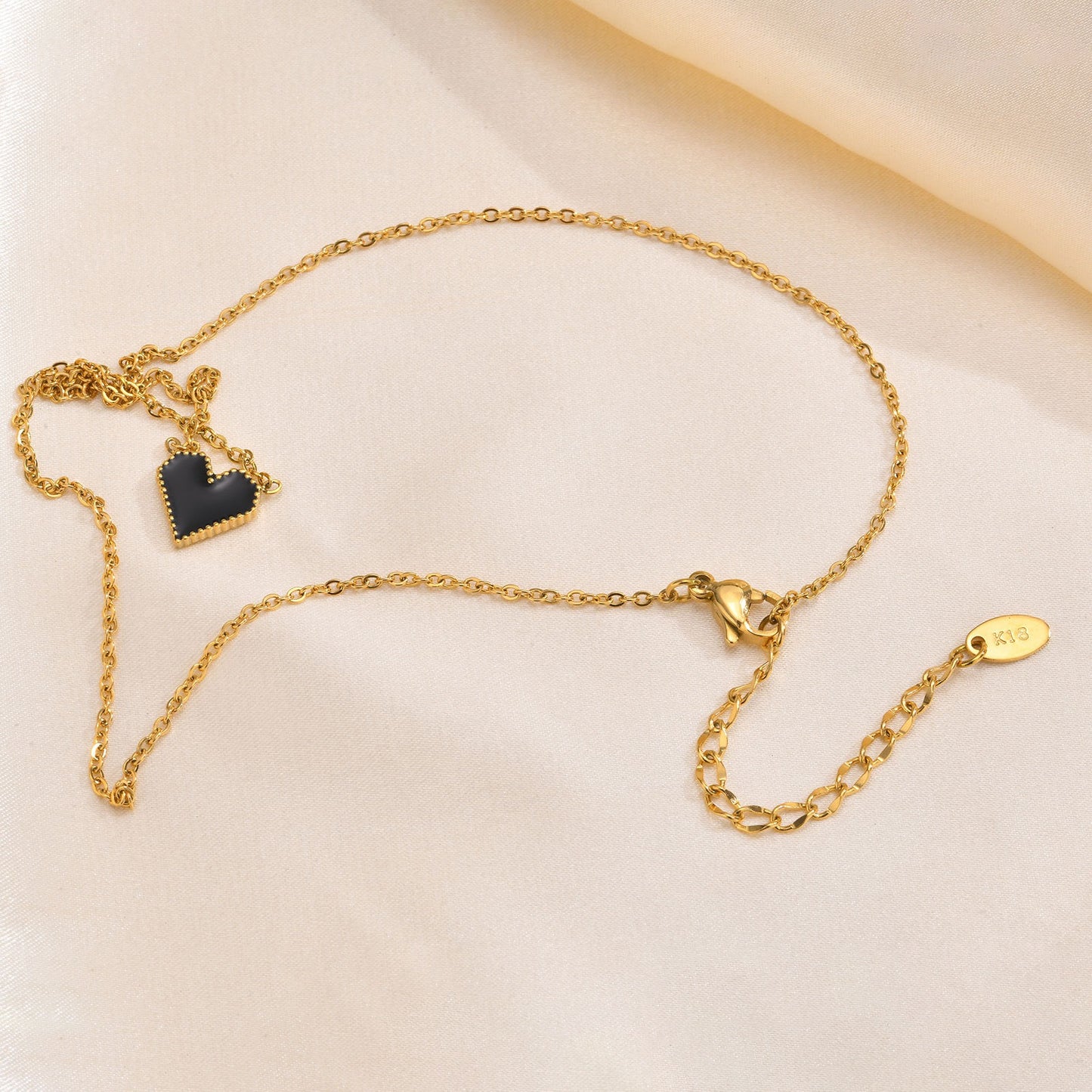 Elegante collar dorado de acero inoxidable con esmalte negro y forma de corazón para mujer NC-1327