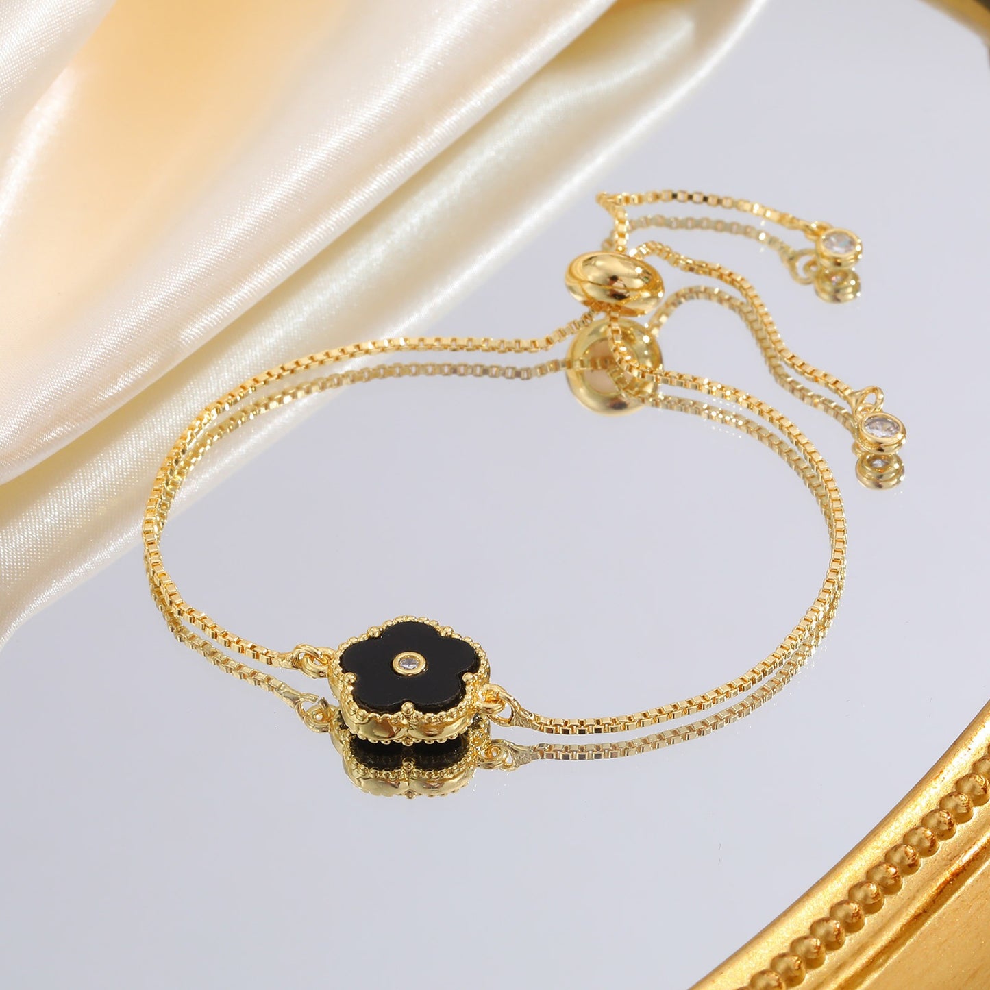 Pulsera de cadena ajustable de cobre con detalles de circonitas cúbicas florales negras Kemstone y acabado dorado: una joya versátil para la elegancia diaria PBR-038