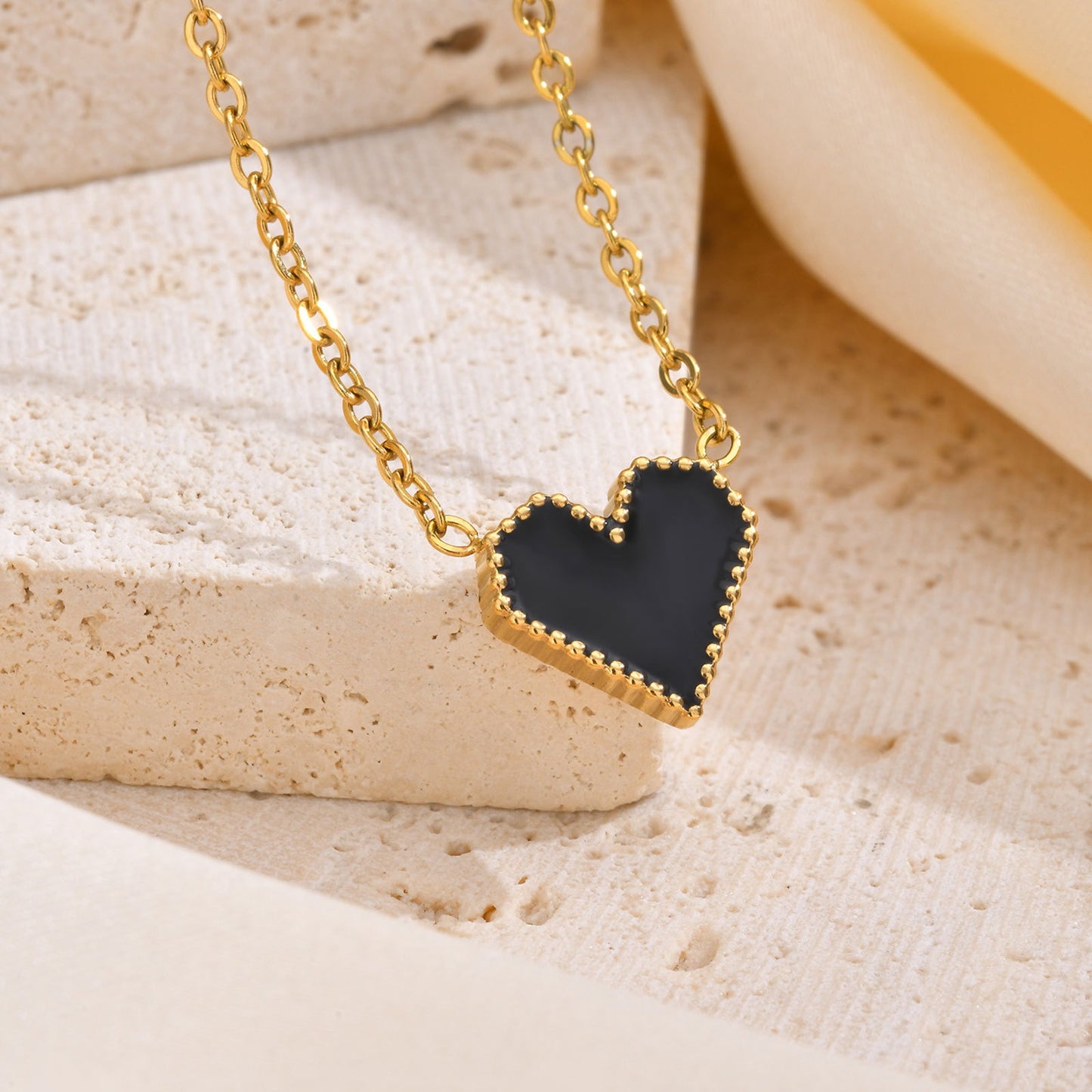 Elegante collar dorado de acero inoxidable con esmalte negro y forma de corazón para mujer NC-1327