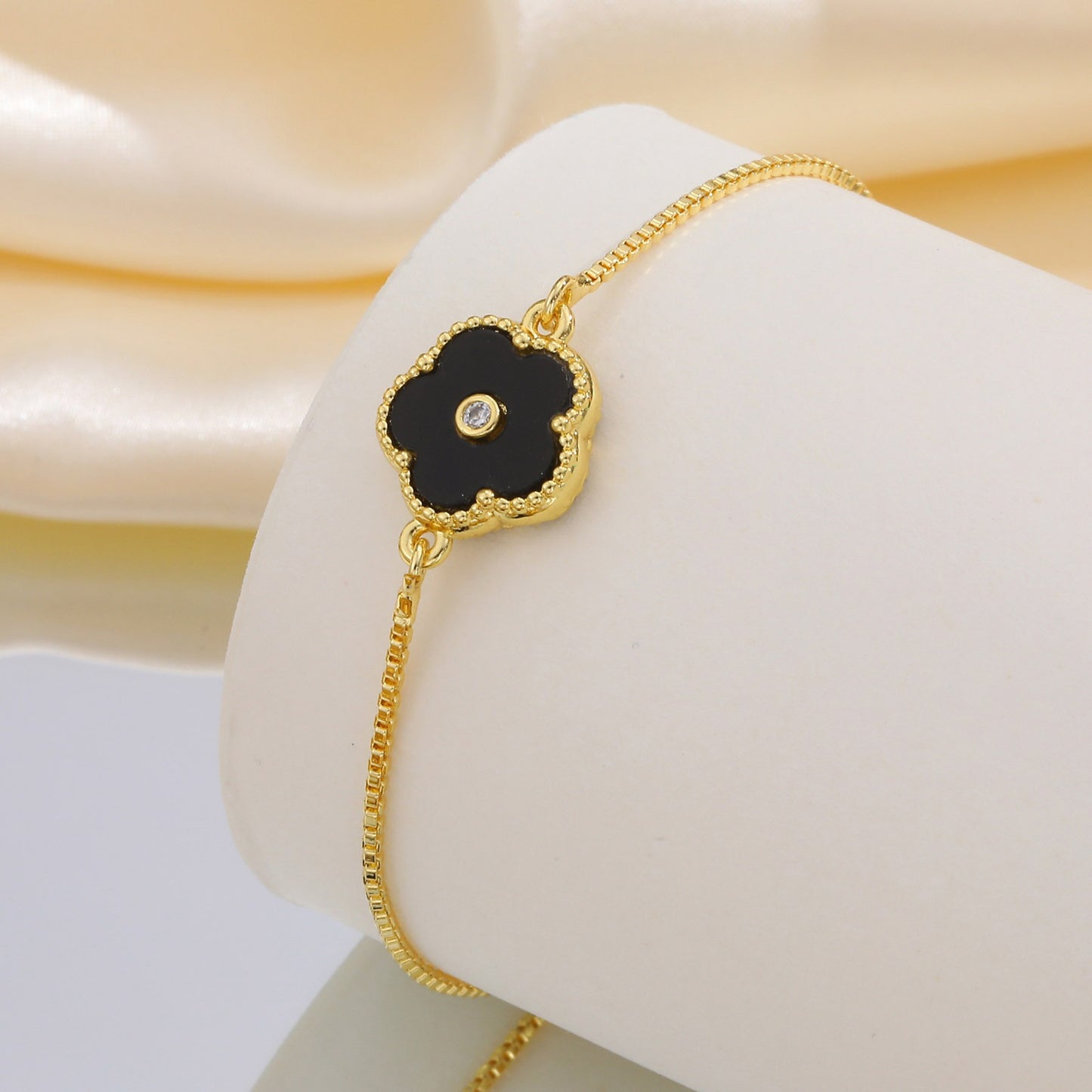 Pulsera de cadena ajustable de cobre con detalles de circonitas cúbicas florales negras Kemstone y acabado dorado: una joya versátil para la elegancia diaria PBR-038