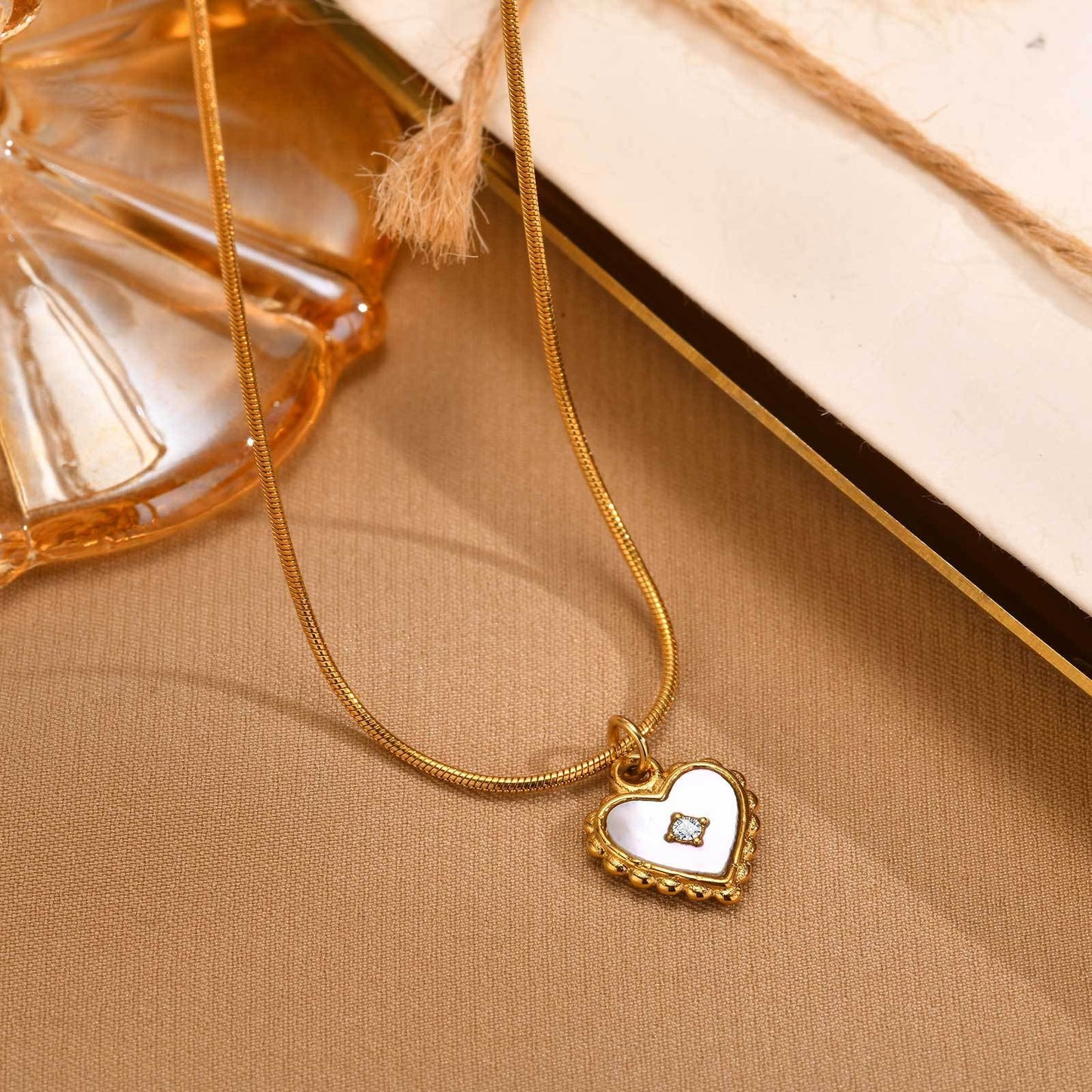 Collar de cadena de serpiente redonda de acero inoxidable con colgante de corazón de circonita y concha. Joyería atemporal en tono dorado para mujer. NC-1912