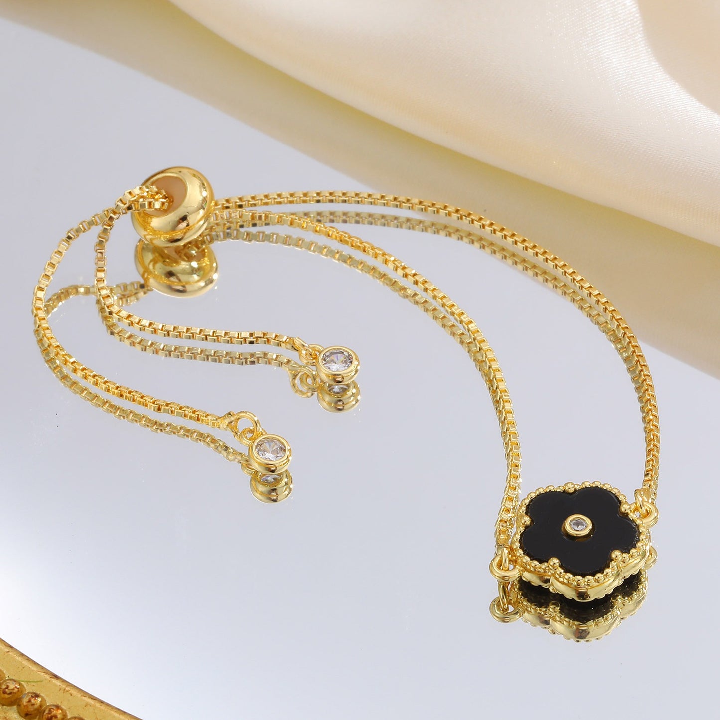 Pulsera de cadena ajustable de cobre con detalles de circonitas cúbicas florales negras Kemstone y acabado dorado: una joya versátil para la elegancia diaria PBR-038