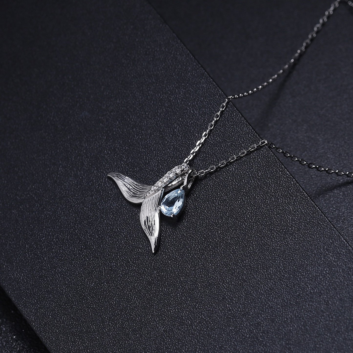 Collar con colgante de cola de ballena, diseño original, hecho a mano por Kemstone, con topacio azul cielo de 4 x 6 mm. Cadena de 45 cm. Elegancia versátil y detalles artísticos.
