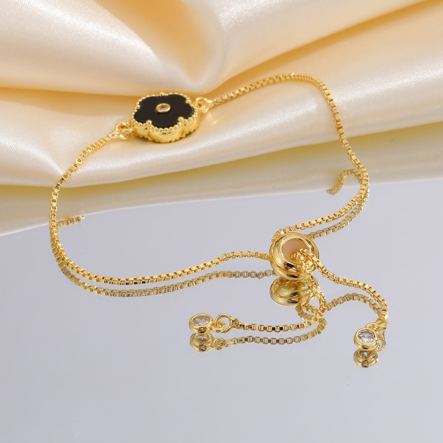 Pulsera de cadena ajustable de cobre con detalles de circonitas cúbicas florales negras Kemstone y acabado dorado: una joya versátil para la elegancia diaria PBR-038