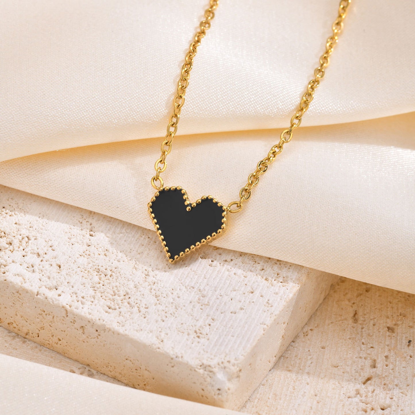 Elegante collar dorado de acero inoxidable con esmalte negro y forma de corazón para mujer NC-1327