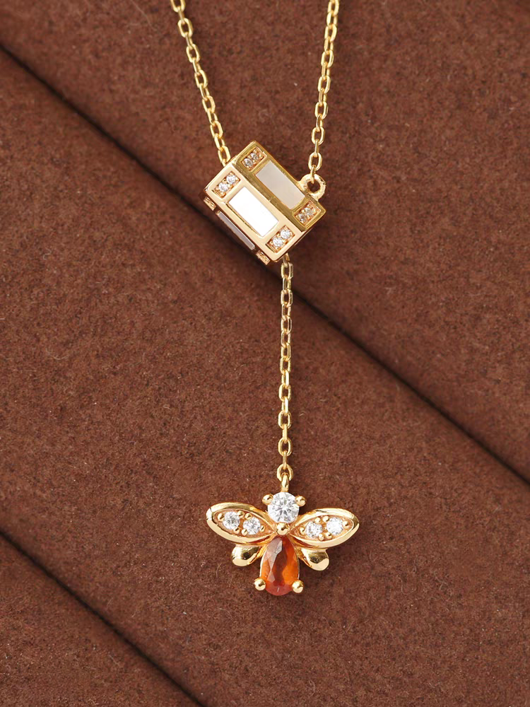 Collar de abeja "Buscador de Miel" de diseño original artesanal de Kemstone. Plata de ley 925, granate espesartita, concha blanca, circonita cúbica y cadena ajustable. Un regalo único de inspiración vintage.