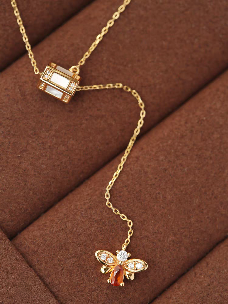 Collar de abeja "Buscador de Miel" de diseño original artesanal de Kemstone. Plata de ley 925, granate espesartita, concha blanca, circonita cúbica y cadena ajustable. Un regalo único de inspiración vintage.