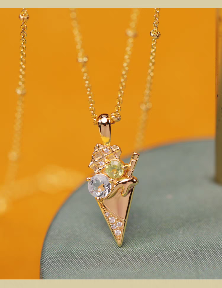 Collar de helado de la colección Sobremesa, diseño original artesanal de Kemstone. Colgante de plata 925 bañada en oro con topacio azul y peridoto. Un regalo de lujo para mujer.